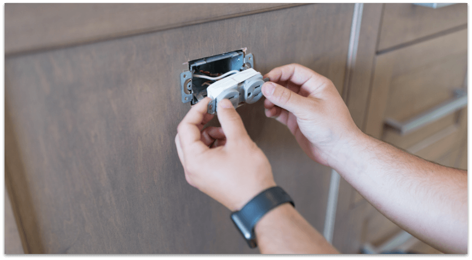 Hands installing new outlet electrical repair