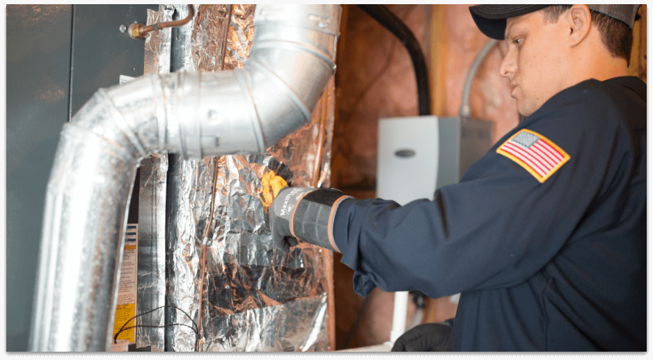 Te certified technician performing furnace maintenance